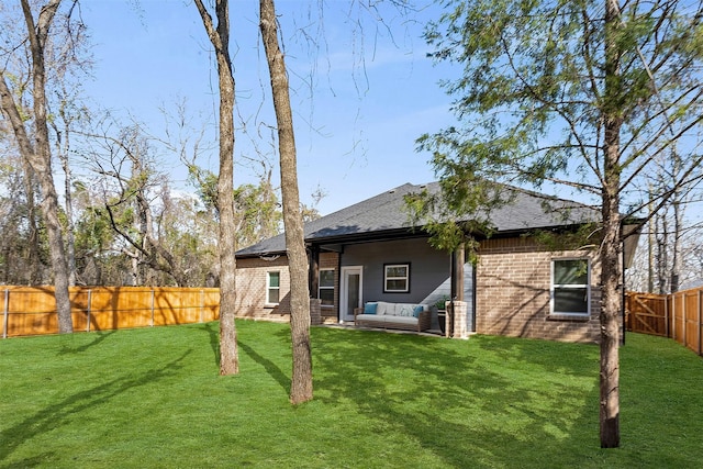 back of house featuring an outdoor living space and a lawn