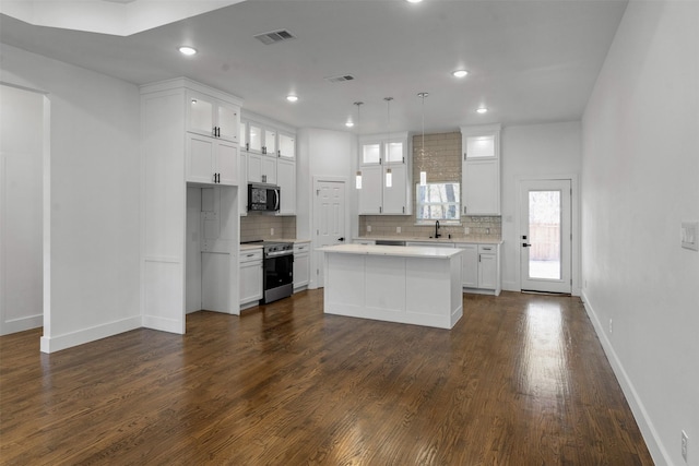 kitchen with appliances with stainless steel finishes, a center island, and white cabinets