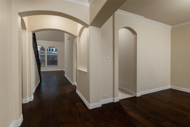 hall featuring baseboards, dark wood finished floors, and crown molding