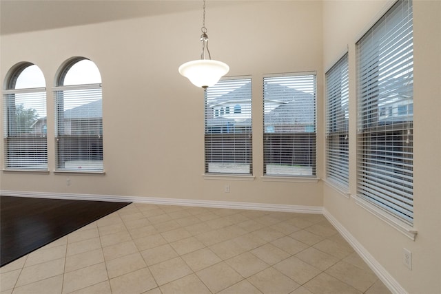 unfurnished room with light tile patterned floors and baseboards