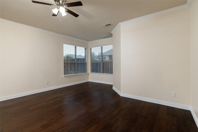 spare room with ornamental molding, dark wood finished floors, visible vents, and baseboards