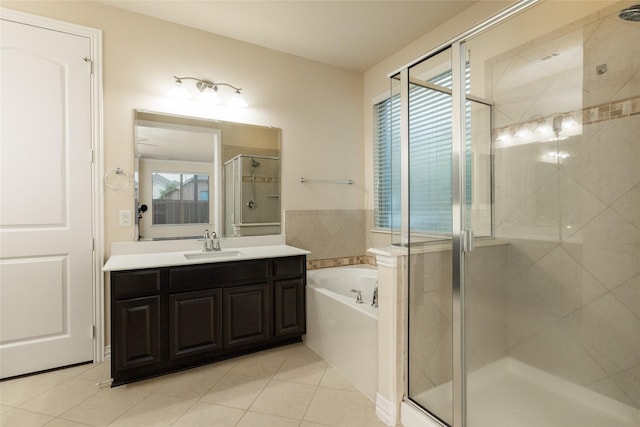 full bath featuring a stall shower, tile patterned floors, vanity, and a bath