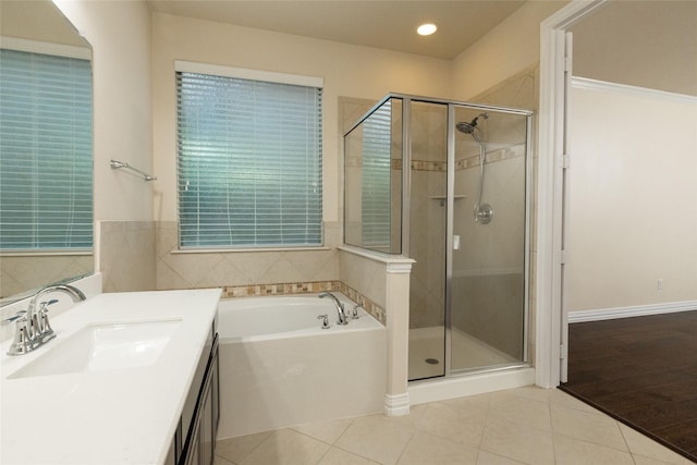 bathroom with a shower stall, tile patterned floors, a bath, vanity, and recessed lighting