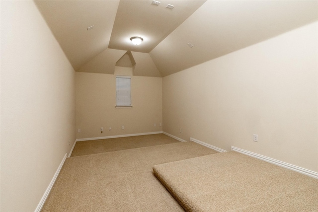 bonus room with vaulted ceiling, carpet floors, and baseboards