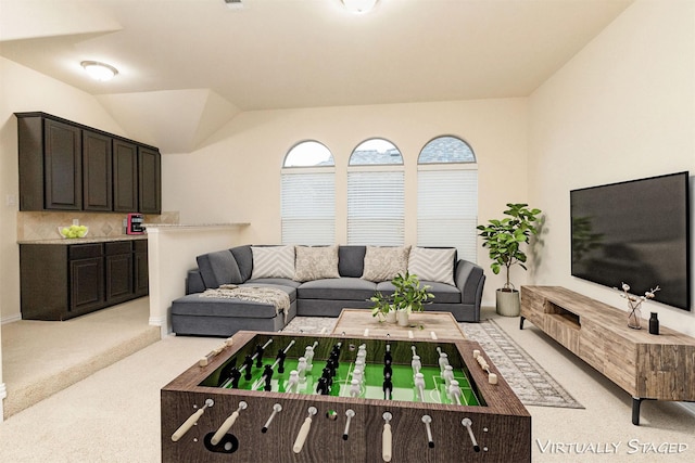 living area featuring light carpet and vaulted ceiling