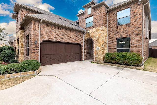 view of front of house with concrete driveway, brick siding, and stone siding