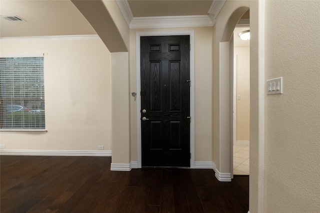 foyer with arched walkways, ornamental molding, dark wood-style flooring, and visible vents