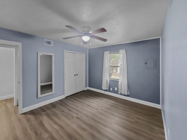 unfurnished bedroom with wood-type flooring, a closet, and ceiling fan