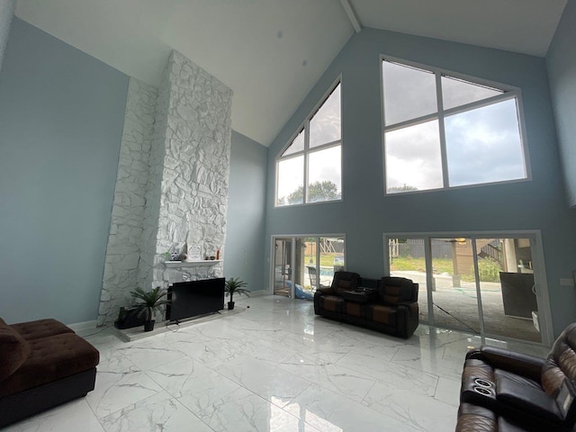 living room with lofted ceiling and a stone fireplace