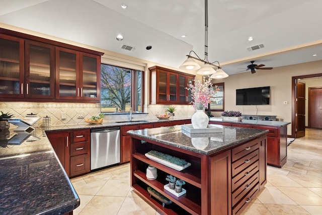 kitchen featuring sink, dishwasher, a kitchen island, pendant lighting, and dark stone counters