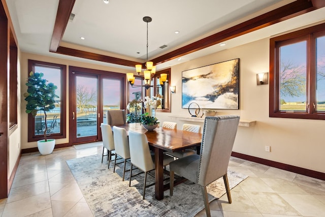 dining area with an inviting chandelier, a raised ceiling, and light tile patterned floors