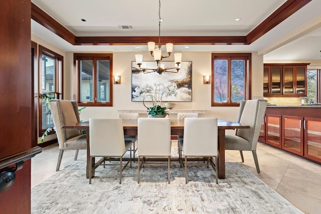 dining space featuring a notable chandelier, a tray ceiling, and light tile patterned floors