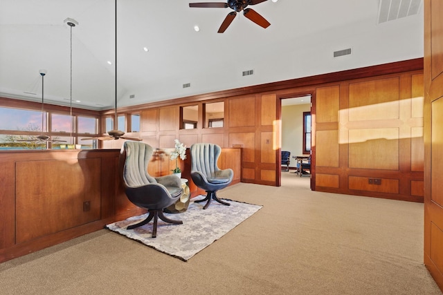 living area with a wealth of natural light, high vaulted ceiling, light colored carpet, and ceiling fan