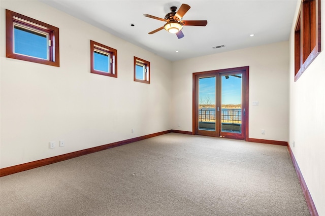 empty room featuring light colored carpet and ceiling fan