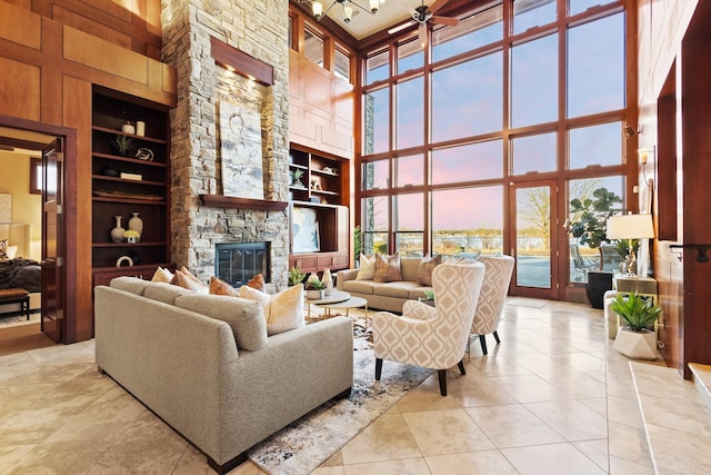 tiled living room featuring built in shelves, a towering ceiling, and a fireplace