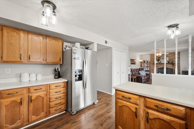 kitchen featuring dark wood-type flooring, stainless steel fridge, and a textured ceiling