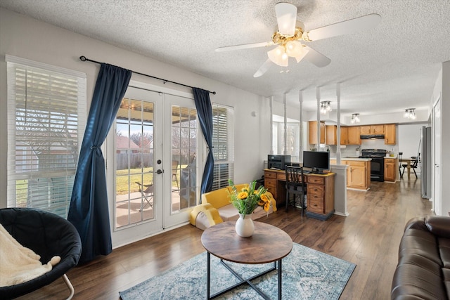 living room with ceiling fan, dark hardwood / wood-style floors, french doors, and a textured ceiling