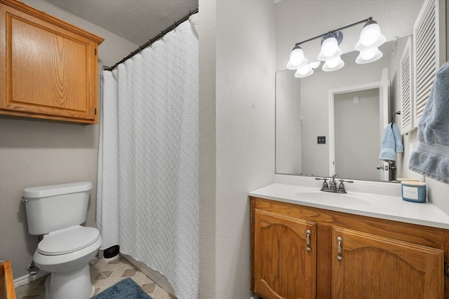 bathroom with tile patterned flooring, vanity, and toilet