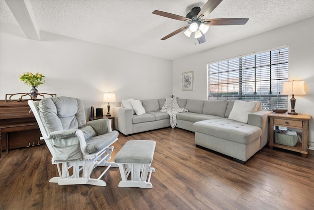 living room featuring dark wood-type flooring, ceiling fan, and a textured ceiling