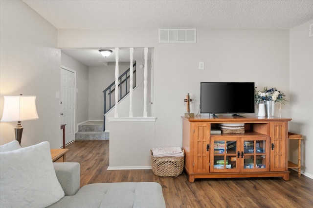 living room with dark hardwood / wood-style floors and a textured ceiling