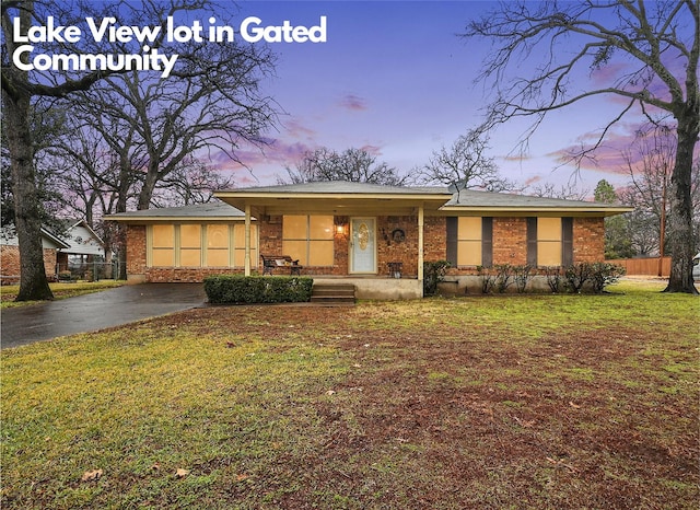 ranch-style home featuring a yard and covered porch