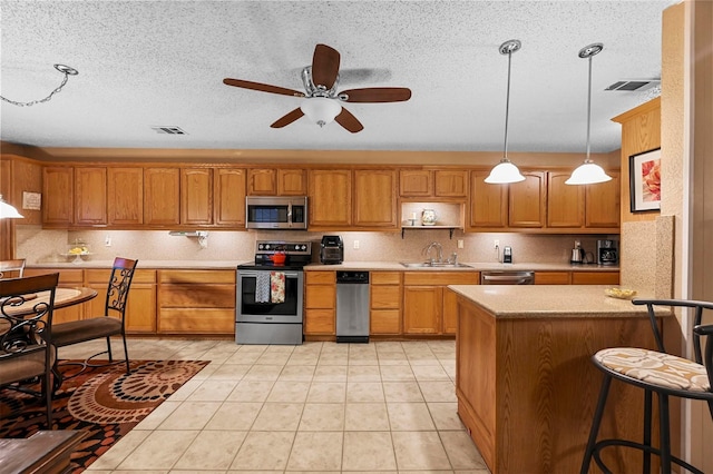 kitchen featuring stainless steel appliances, tasteful backsplash, sink, and pendant lighting