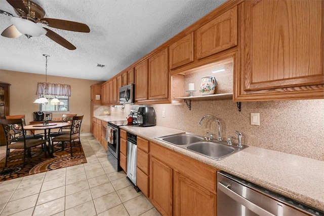 kitchen featuring appliances with stainless steel finishes, sink, backsplash, hanging light fixtures, and light tile patterned floors