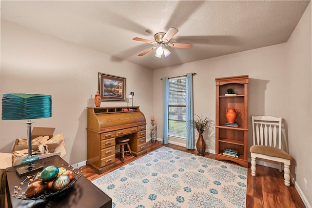 living area featuring hardwood / wood-style flooring, a textured ceiling, and ceiling fan