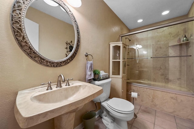 bathroom featuring toilet, tile patterned flooring, and combined bath / shower with glass door