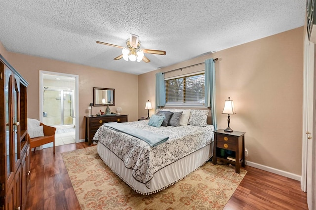 bedroom with connected bathroom, ceiling fan, hardwood / wood-style flooring, and a textured ceiling