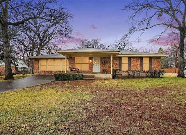 ranch-style home featuring a yard and covered porch