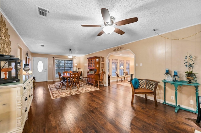 dining room featuring crown molding, ceiling fan, dark hardwood / wood-style floors, and a textured ceiling