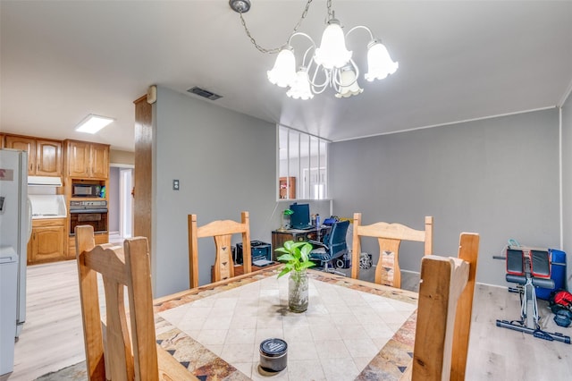 dining area with an inviting chandelier and light hardwood / wood-style floors