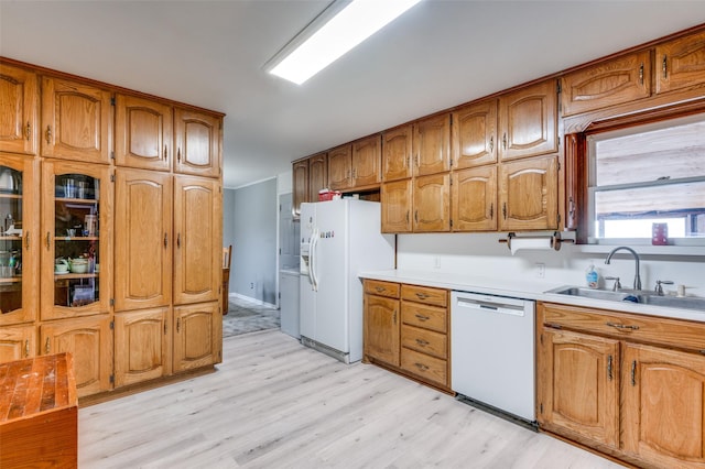 kitchen with sink, white appliances, and light hardwood / wood-style flooring