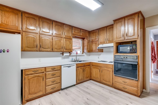 kitchen featuring light wood-type flooring, sink, and black appliances