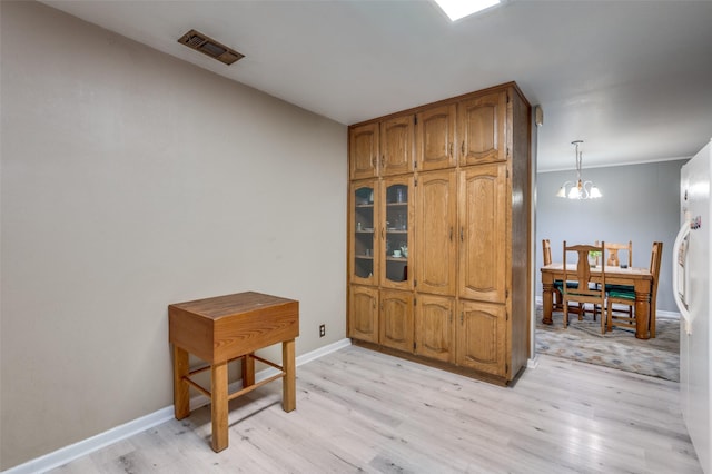 interior space with a notable chandelier and light wood-type flooring