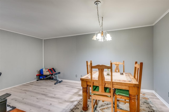 dining space featuring hardwood / wood-style flooring, ornamental molding, and a chandelier