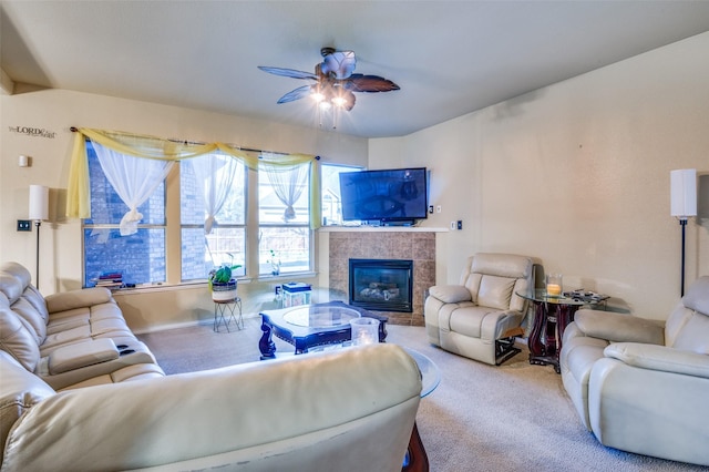 carpeted living room featuring a tiled fireplace, a ceiling fan, and baseboards