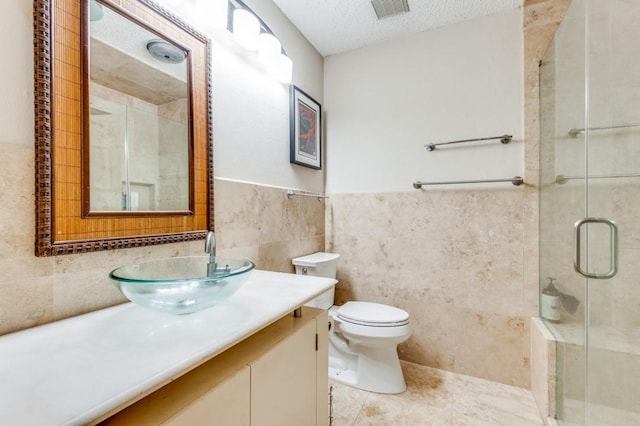 full bath featuring toilet, tile walls, a stall shower, visible vents, and vanity