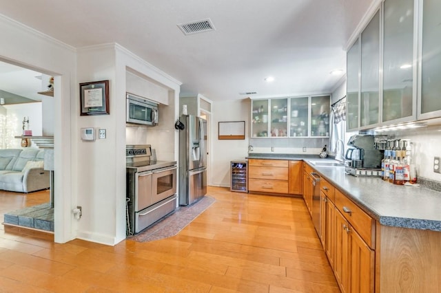 kitchen featuring stainless steel appliances, wine cooler, light wood-type flooring, visible vents, and glass insert cabinets