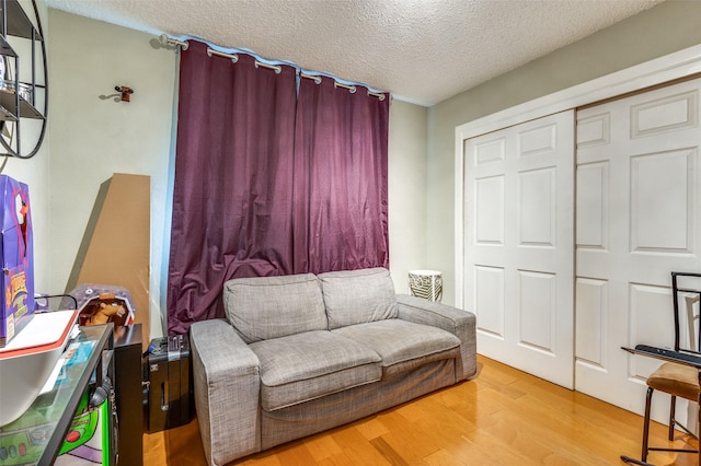 sitting room with light hardwood / wood-style flooring and a textured ceiling