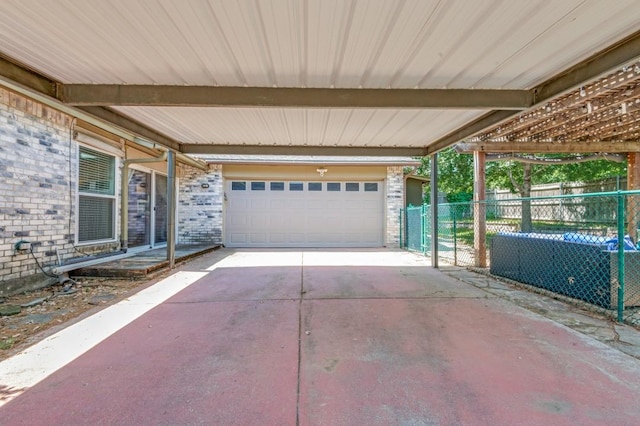 view of patio / terrace featuring a garage, driveway, a carport, and fence