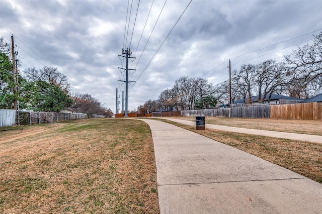 view of home's community with a yard and fence