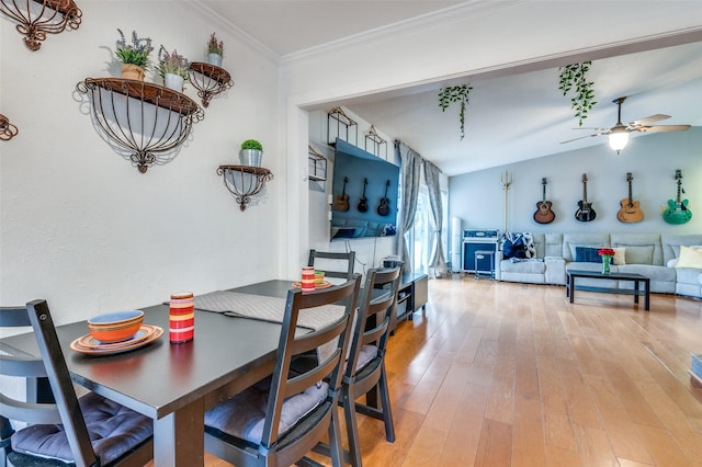 dining area featuring wood-type flooring, ornamental molding, and ceiling fan