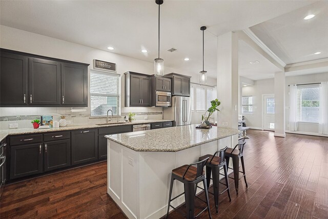 kitchen with pendant lighting, sink, a breakfast bar area, and stainless steel appliances