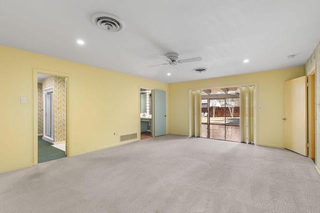 carpeted spare room featuring ceiling fan