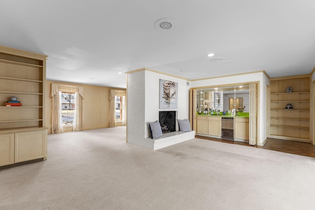 unfurnished living room featuring light colored carpet, ornamental molding, a fireplace, and built in features