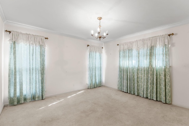 carpeted spare room featuring crown molding, plenty of natural light, and an inviting chandelier