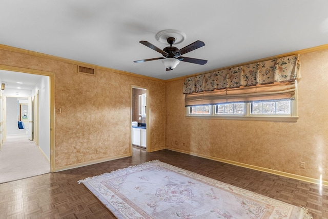 empty room with crown molding, dark parquet flooring, and ceiling fan