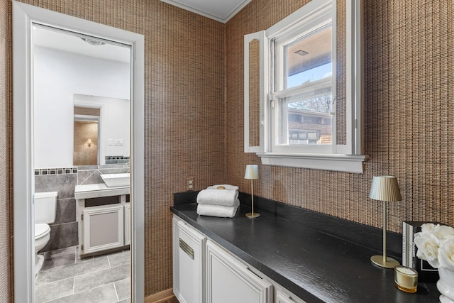 kitchen with white cabinetry, tile walls, and light tile patterned floors